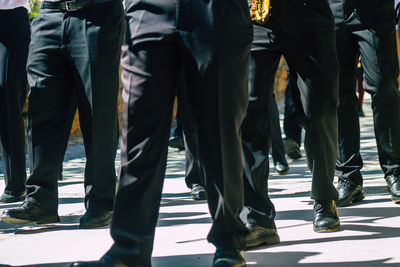 Low section of people walking on sidewalk in city