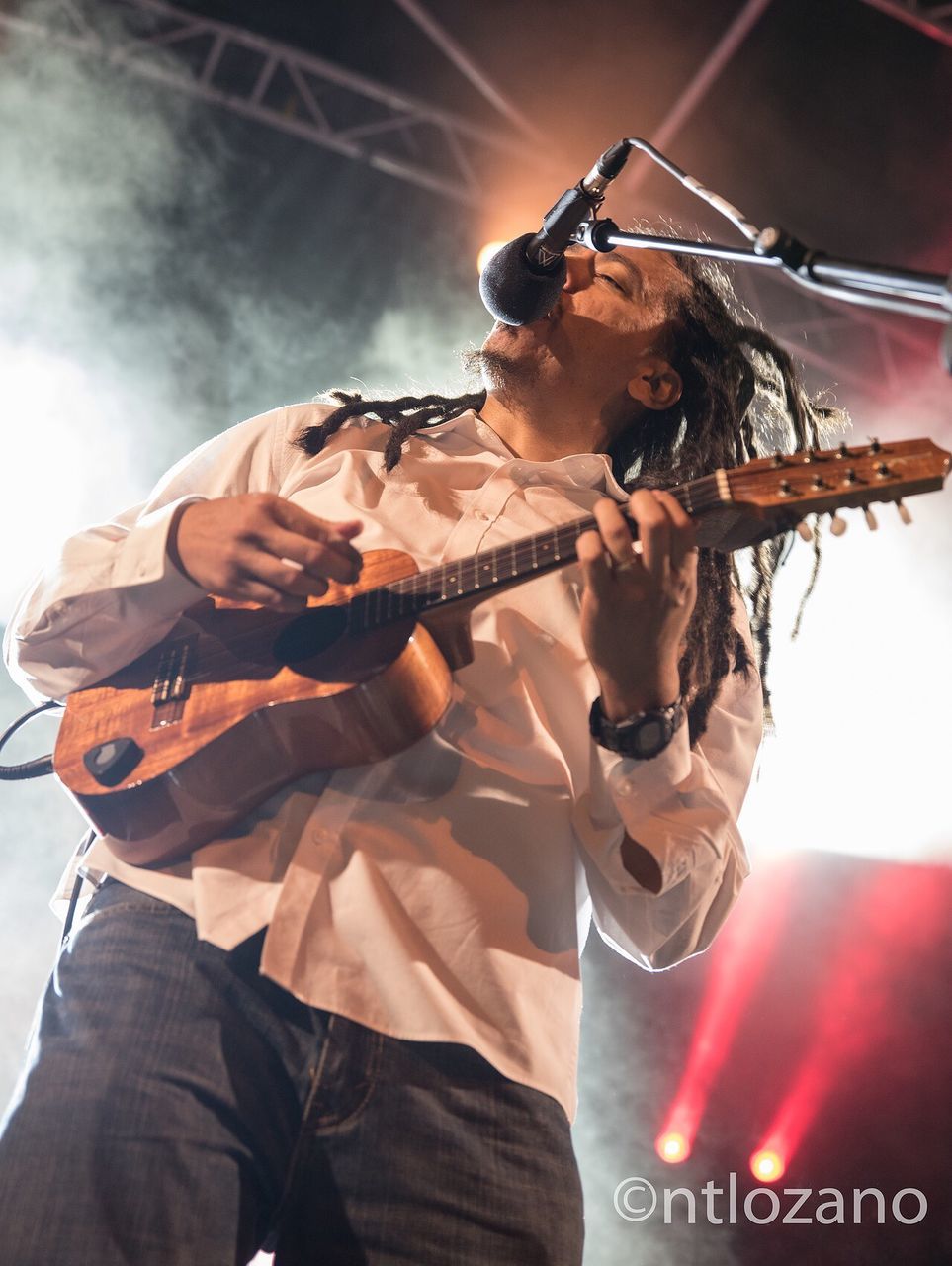 three quarter length, one person, holding, young adult, young men, real people, front view, music, glasses, standing, waist up, illuminated, low angle view, performance, indoors, men, mature adult, weapon, stage