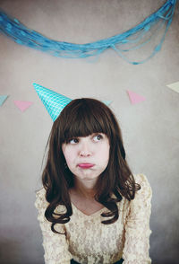 Woman looking away against wall during birthday