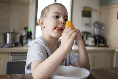 Little preschooler boy eating ice cream gelato at home