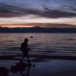 Man standing on mountain at sunset