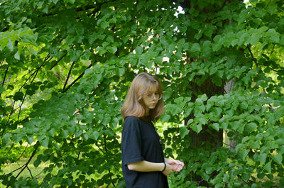 The girl is photographed near the greenery, portrait