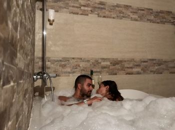 Young woman lying down in bathroom at home