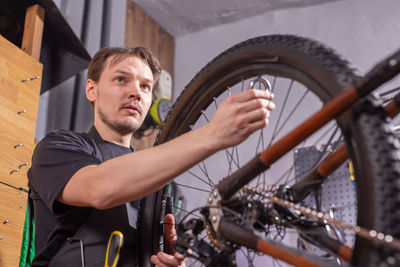 Low angle view of worker repairing bicycle