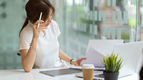 Midsection of woman using smart phone on table