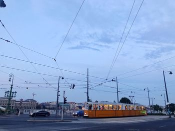 Overhead cable cars on road against sky