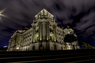 Low angle view of illuminated building against sky at dusk