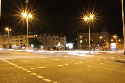 Light trails on road along buildings at night