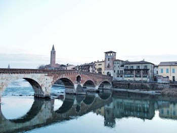 Ponte pietra reflecting in adige river against sky