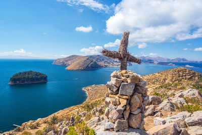 Cross by sea against sky