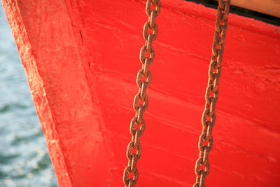 Close-up of chain hanging on rope against sea