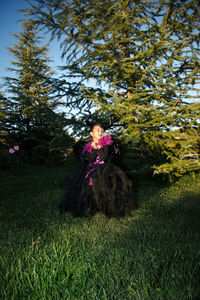 Rear view of woman sitting on grassy field