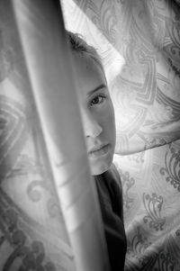 Portrait of teenage girl by curtain