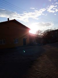 Houses against sky at sunset