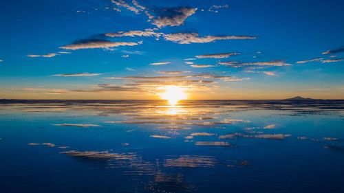 Reflection of sunrise on salt lake at salar de uyuni