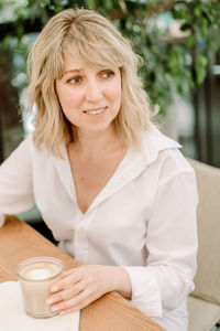 Portrait of woman with coffee cup on table