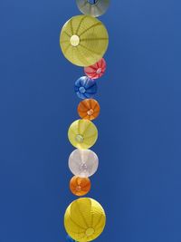 Low angle view of lanterns against clear blue sky