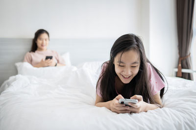 Happy woman lying on bed in bedroom