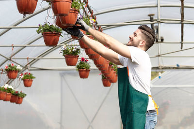 Smiling man working in greenhouse