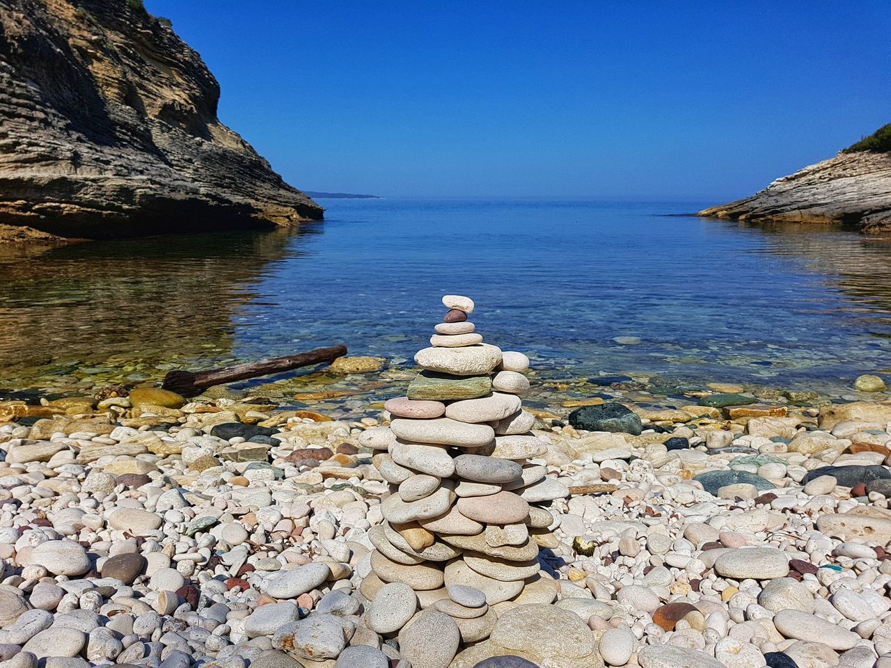 water, rock, solid, rock - object, beauty in nature, scenics - nature, sea, tranquil scene, sky, stone - object, tranquility, nature, beach, stone, clear sky, day, no people, pebble, land