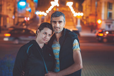 Portrait of smiling young man on city street at night