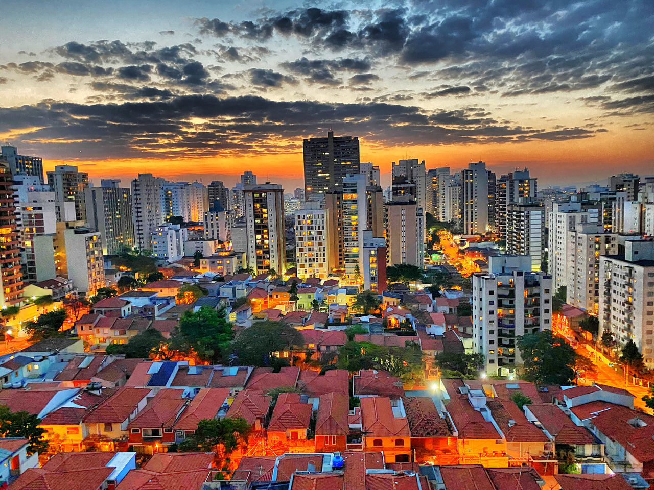 HIGH ANGLE VIEW OF STREET AND BUILDINGS AGAINST SKY AT SUNSET