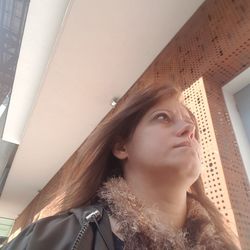 Low angle portrait of young woman looking away