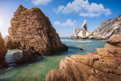 Scenic view of rocks in sea against sky