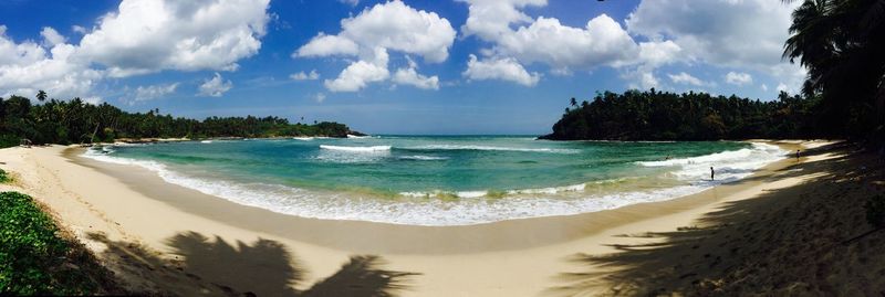 Scenic view of beach against cloudy sky