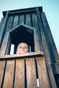 Low angle view of boy in play equipment