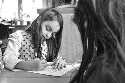 High angle view of girl sitting on table