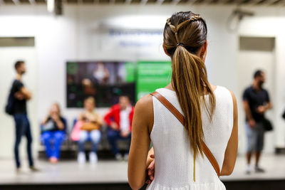 Rear view of woman standing at subway station