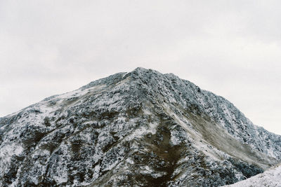 Low angle view of snowcapped mountain against sky