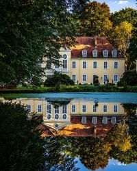 Reflection of trees and buildings on lake