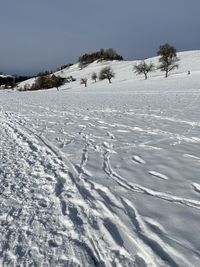 Scenic view of snow covered land against sky