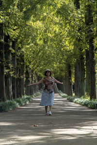 Full length portrait of a woman walking on footpath