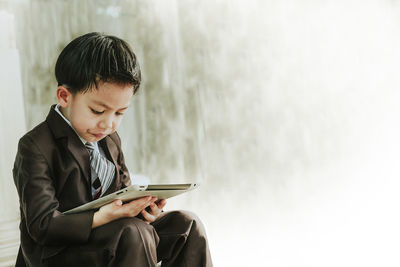 Man looking away while sitting on mobile phone