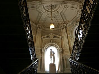 Low angle view of statues and pendant light in historic building