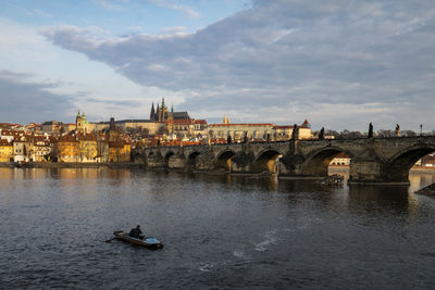 Bridge over river in city against sky