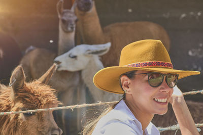 Young tourist takes selfies of alpacas and llamas on the farm. farming industry in peru. farm life 