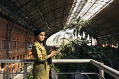 Portrait of modern muslim woman using her smartphone on a train station