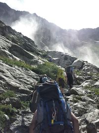 Rear view of man on mountain against sky