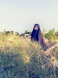 Portrait of woman on field against sky