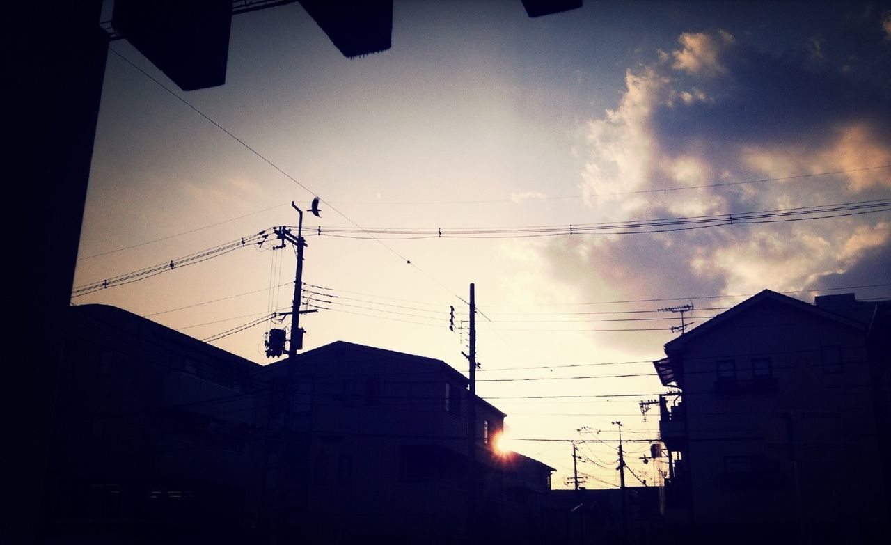 building exterior, architecture, built structure, power line, sunset, sky, low angle view, electricity pylon, silhouette, electricity, cable, residential structure, power supply, building, residential building, house, cloud - sky, fuel and power generation, city, sunlight