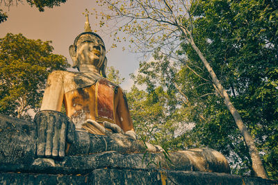 Low angle view of statue against trees