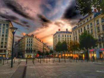 Buildings against cloudy sky at sunset