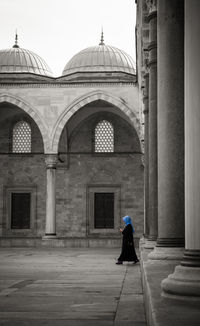 A woman in a blue headscarf walking in the courtyard of the süleymaniye mosque - istanbul