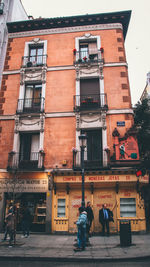 Rear view of people walking on street against buildings