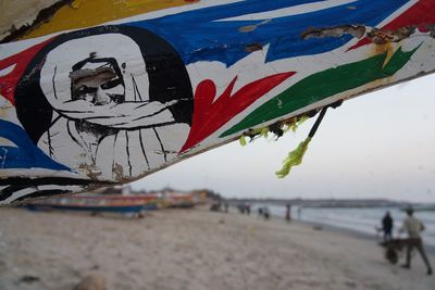 Close-up of flag on beach against sky
