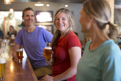 Three female friends enjoy a beer at a brewery in government camp, or.